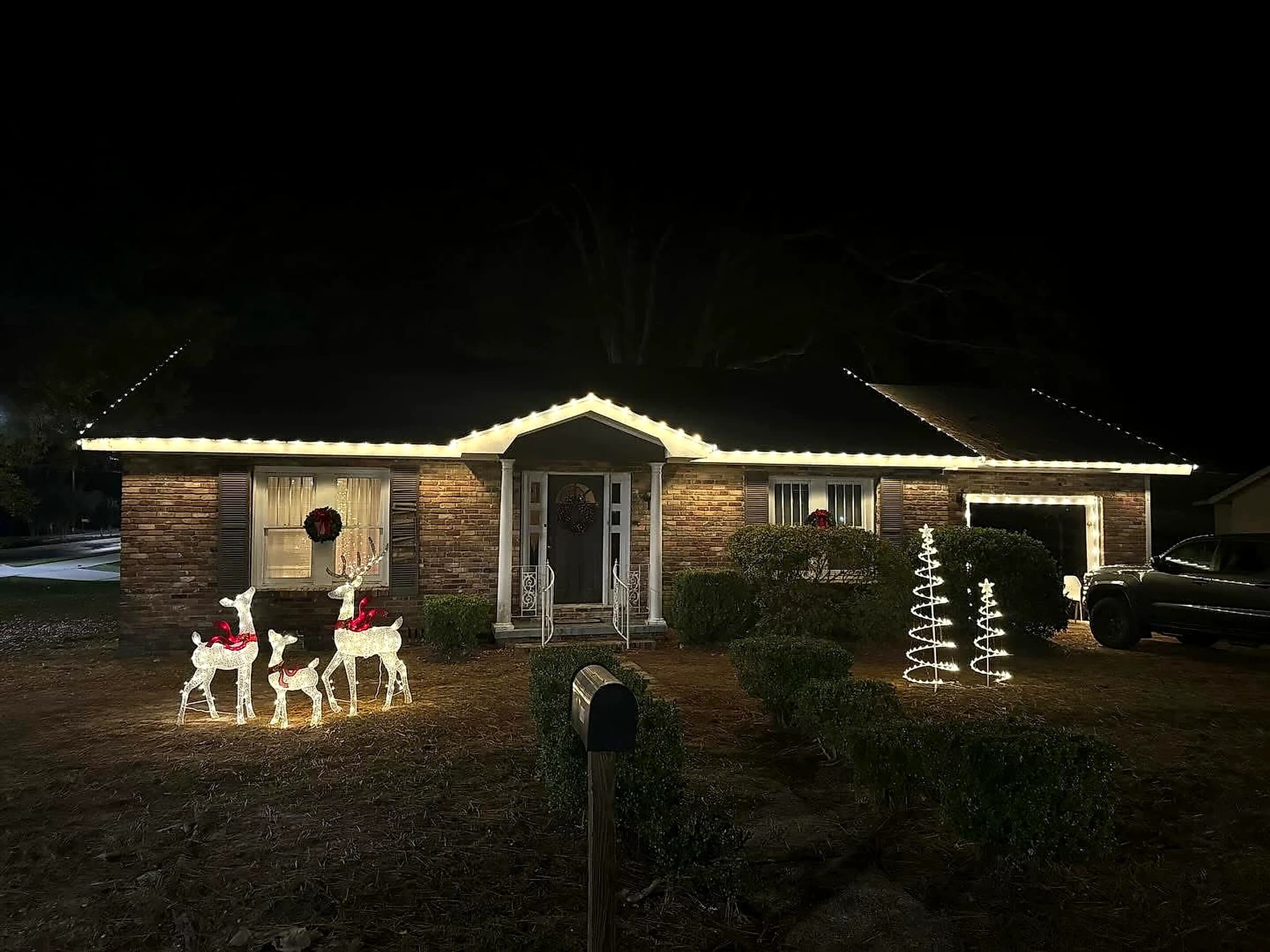 Southeast Lights display in Hattiesburg: a brick ranch with warm white C9 running the length of the front eave and up over the entry gable, evenly spaced from corner to corner